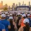 Gün doğumunda şehir maratonunun start alanında beyaz şapkalı koşucular