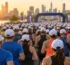 Gün doğumunda şehir maratonunun start alanında beyaz şapkalı koşucular